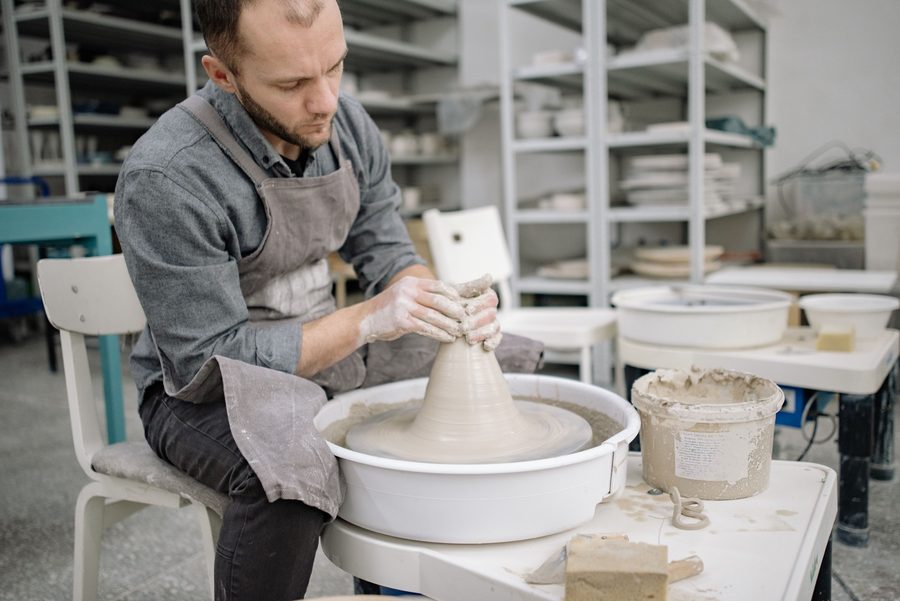 Potter working at a pottery wheel in a workshop