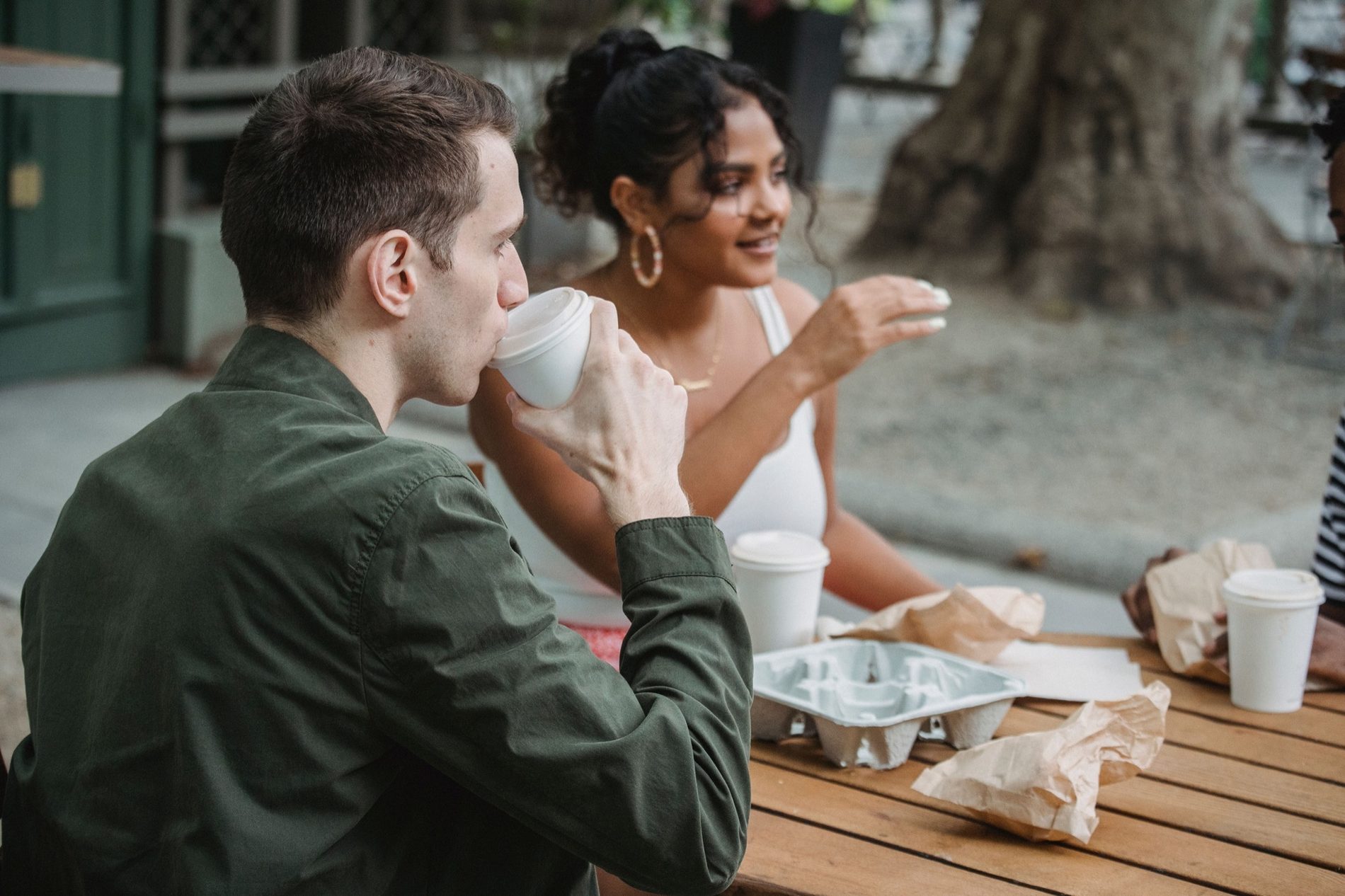 Two friends in warm conversation over coffee at an outdoor café